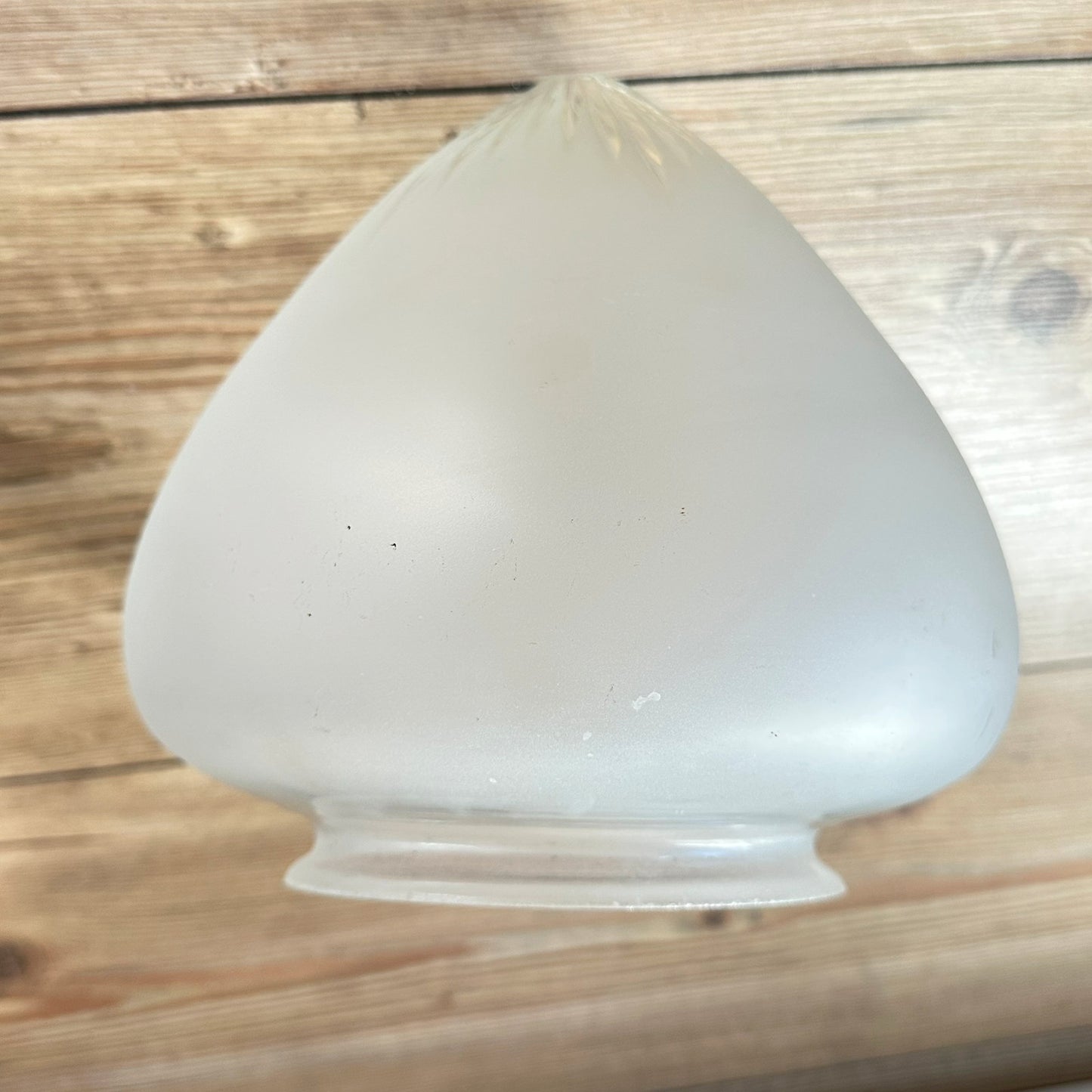 Gamle ovale lampeskjermer i semi-transparent glass med en kuttet stjerne øverst.