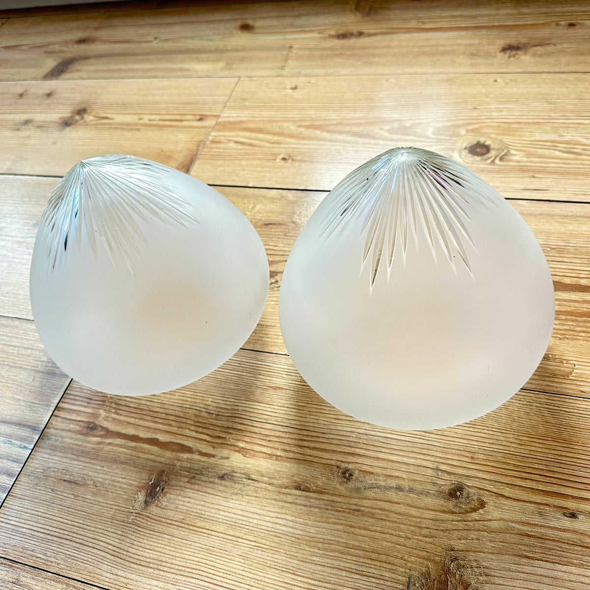 Gamle ovale lampeskjermer i semi-transparent glass med en kuttet stjerne øverst.