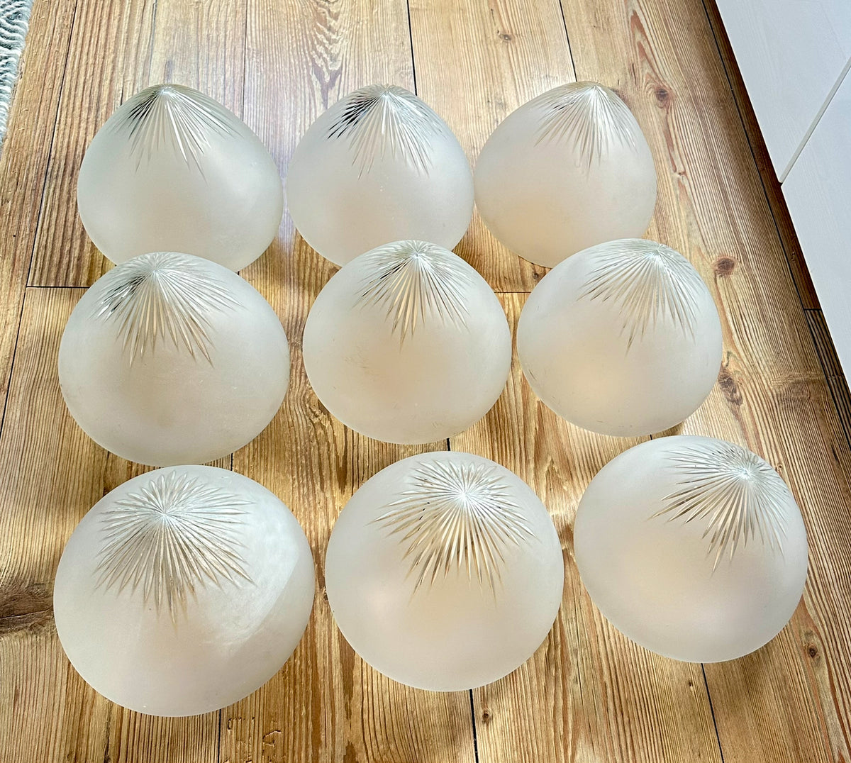 Gamle ovale lampeskjermer i semi-transparent glass med en kuttet stjerne øverst.