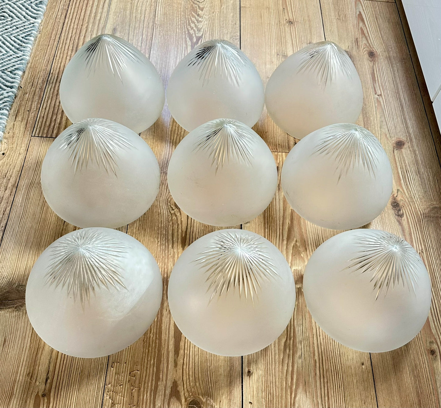 Gamle ovale lampeskjermer i semi-transparent glass med en kuttet stjerne øverst.