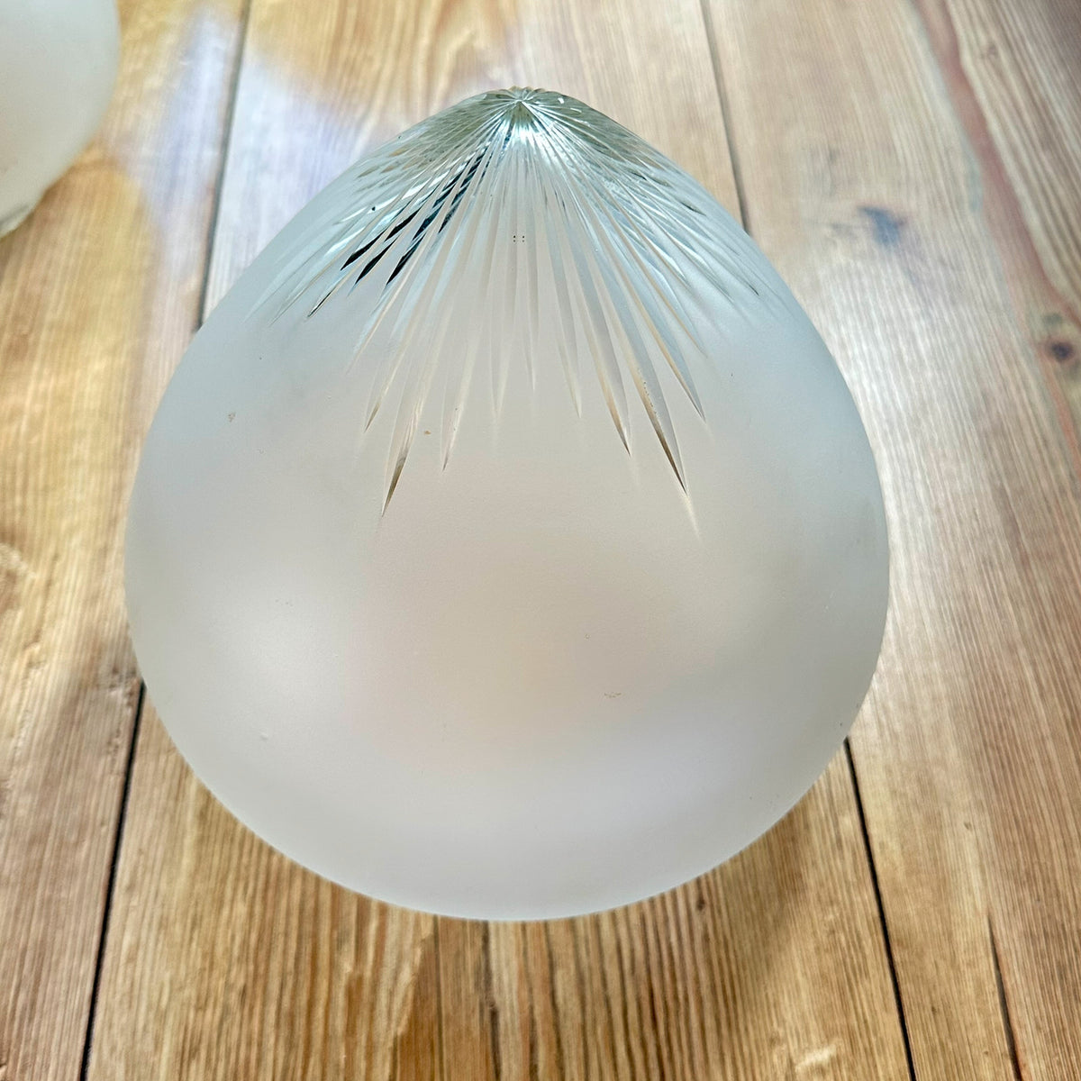 Gamle ovale lampeskjermer i semi-transparent glass med en kuttet stjerne øverst.